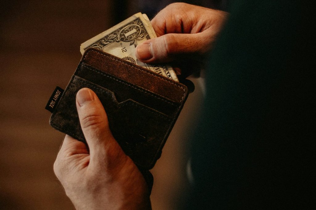 Hands taking dollar bills out of a wallet