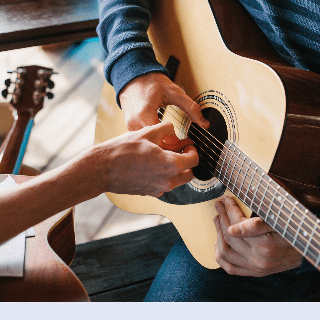 teacher and student playing guitar